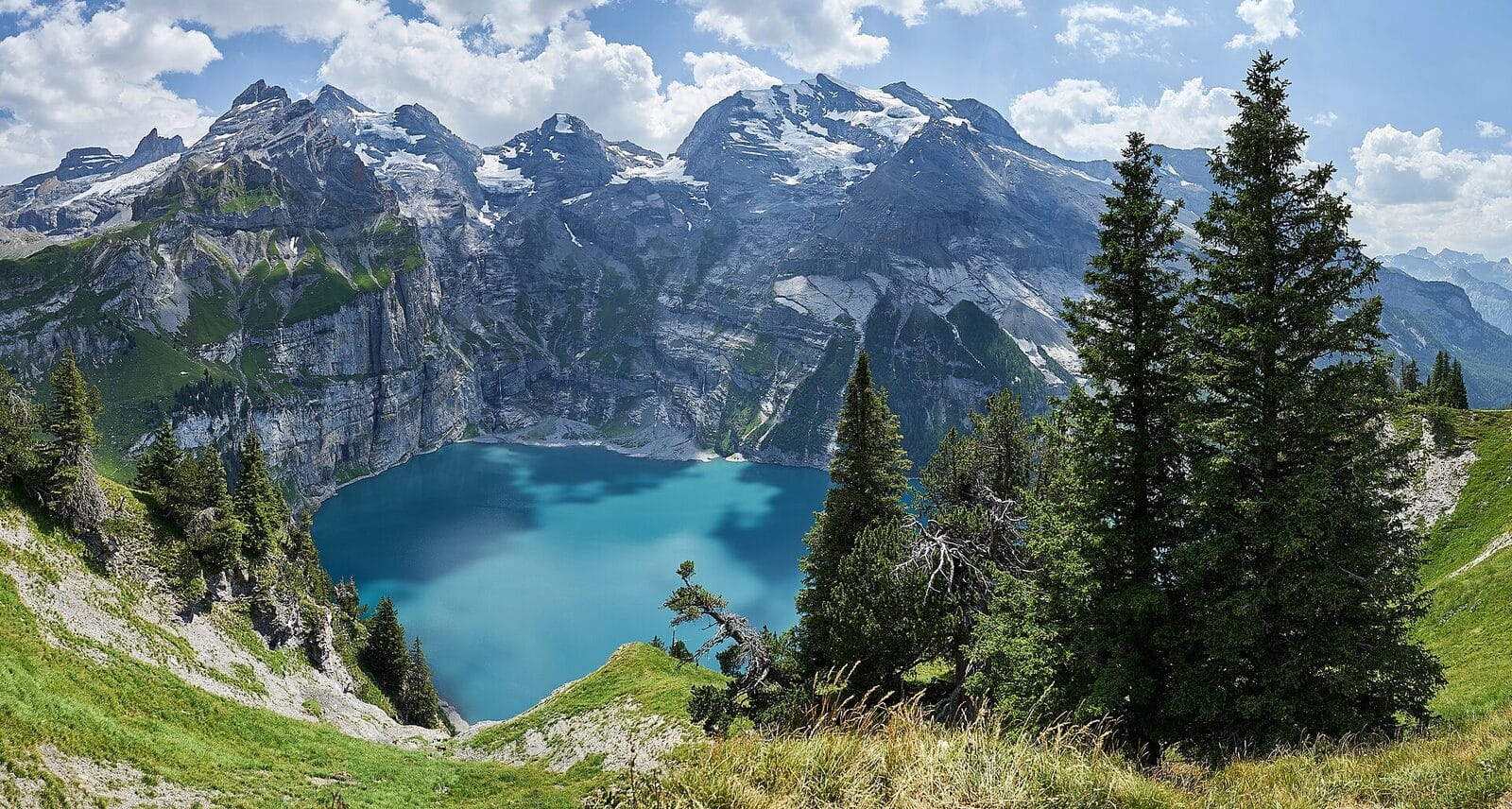 The turquoise Oeschinensee lake beneath the Swiss Alps