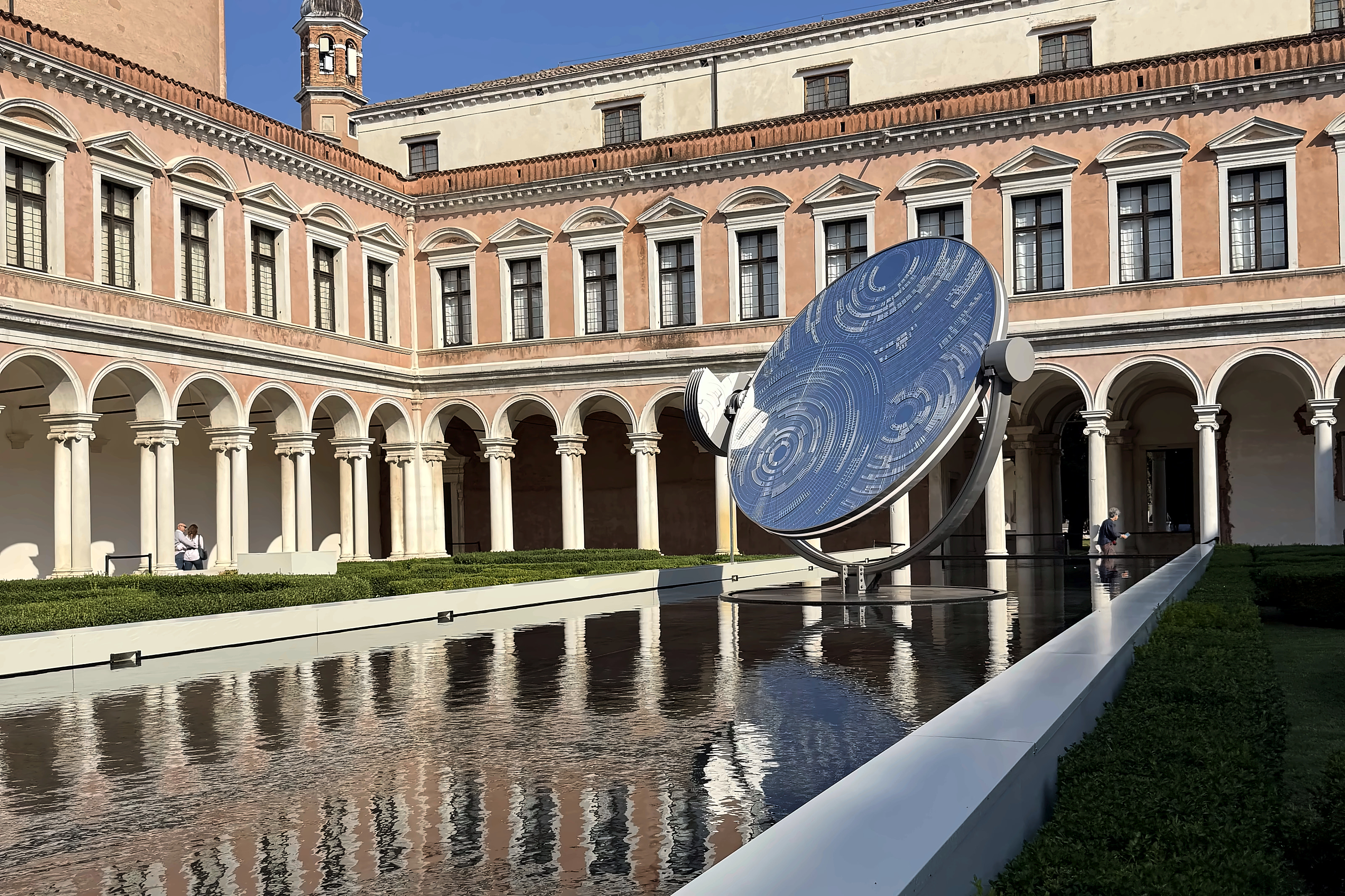 A mirrored disc standing in the reflecting pool of the Fondazione Cini cloister on San Giorgio Maggiore